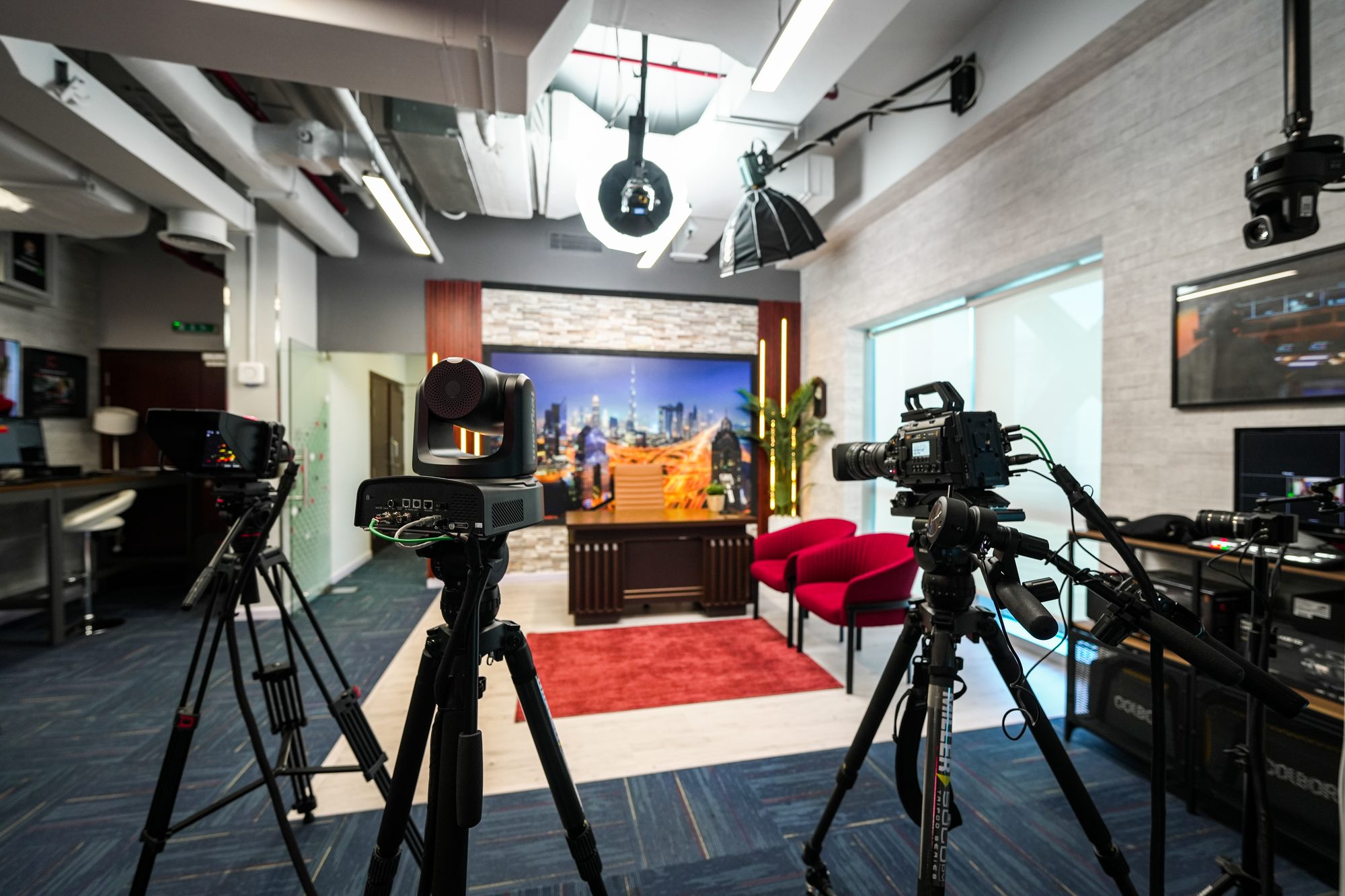 The MCX set seen wide, cameras on tripods and a moving light above